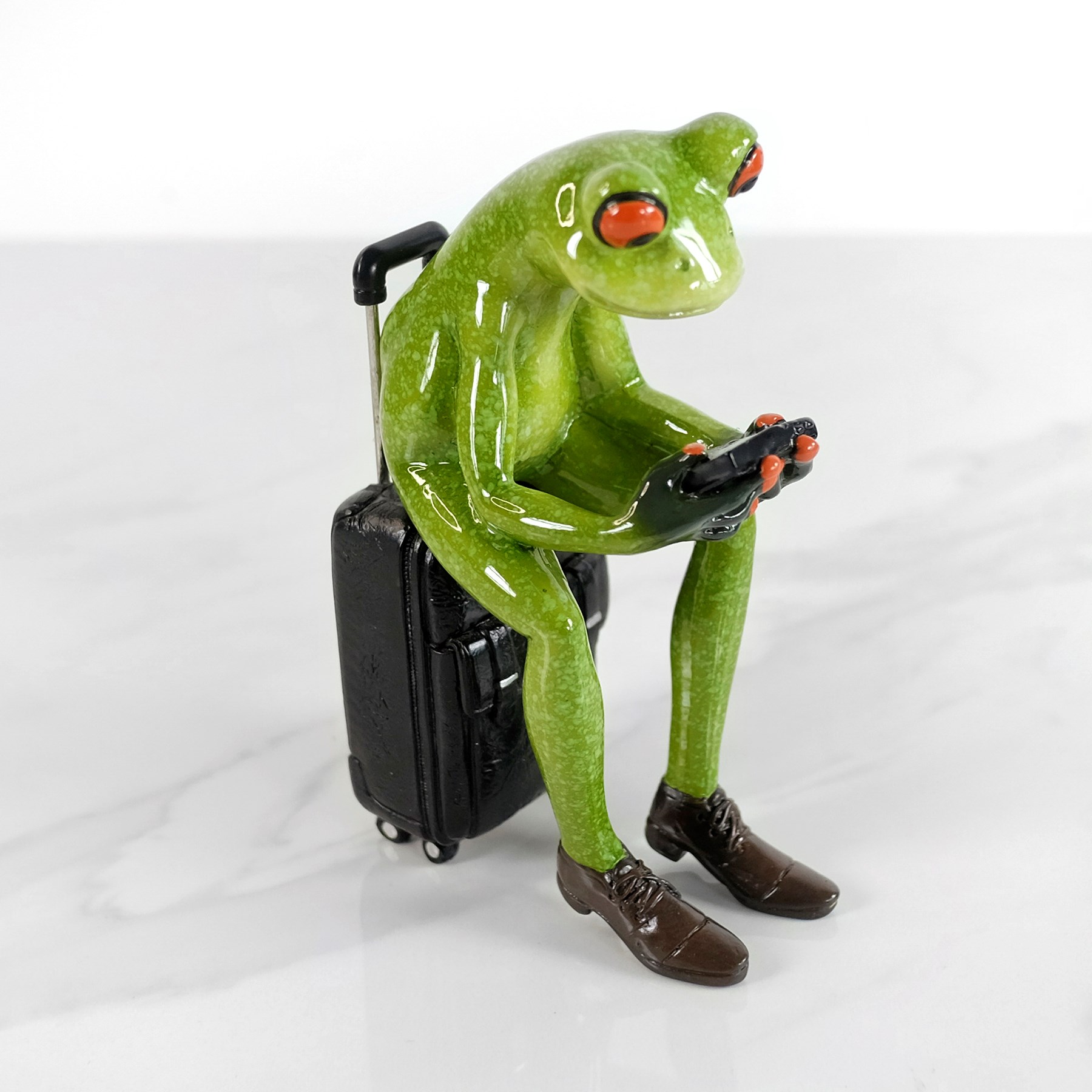 Image de Grenouille sur valise et cellulaire